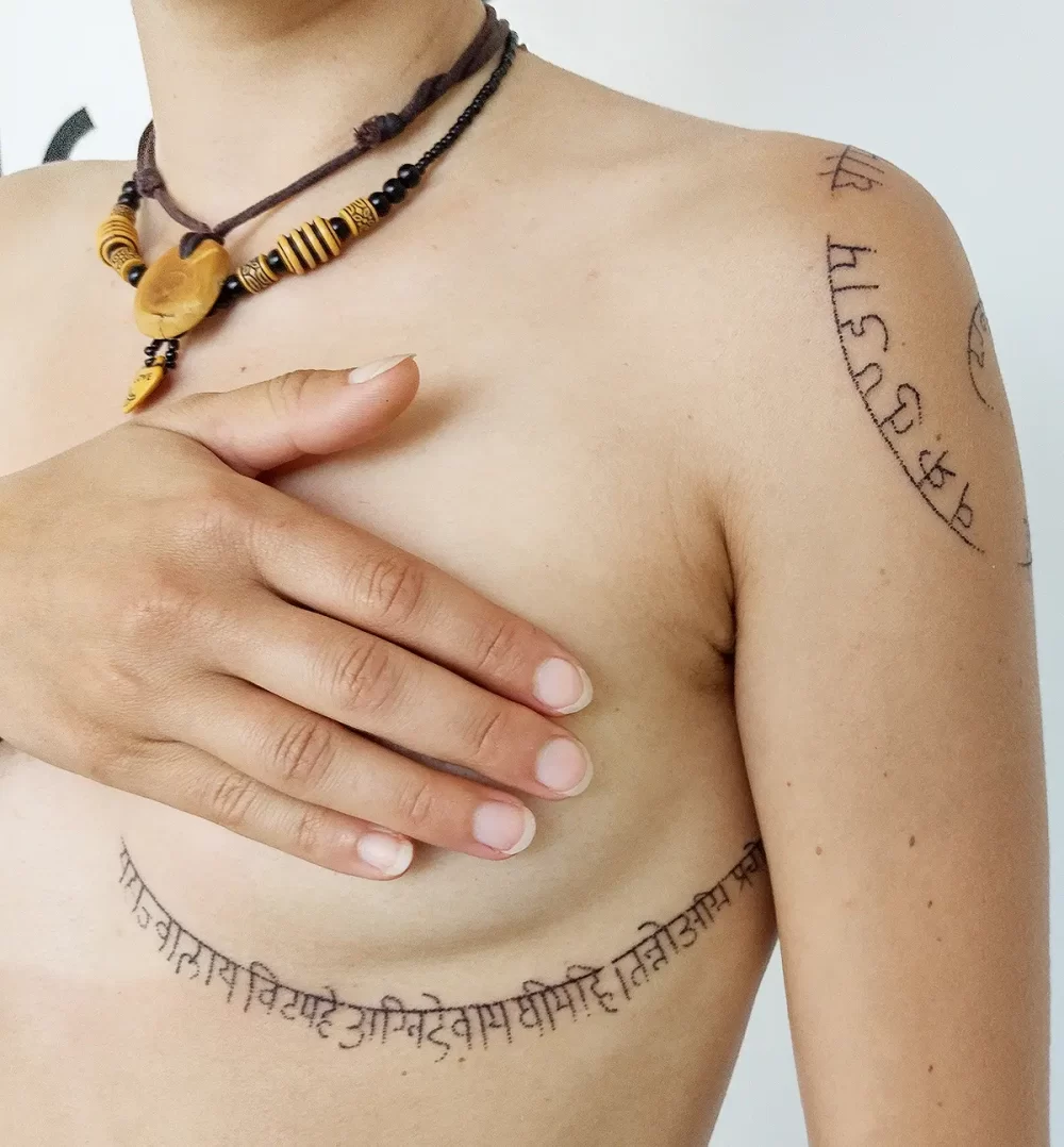 Tatouage mantra spirituel en sanskrit réalisé à la main Tatouage mantra sacré en sanskrit réalisé à la main sur le corps d'une femme