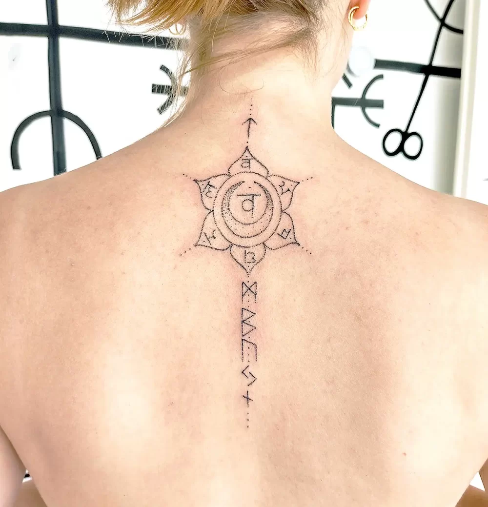tatouage lotus dos femme spirituel énergétique Tattoo lotus sur le haut du dos d'une femme, symbole de centrage et d’énergie