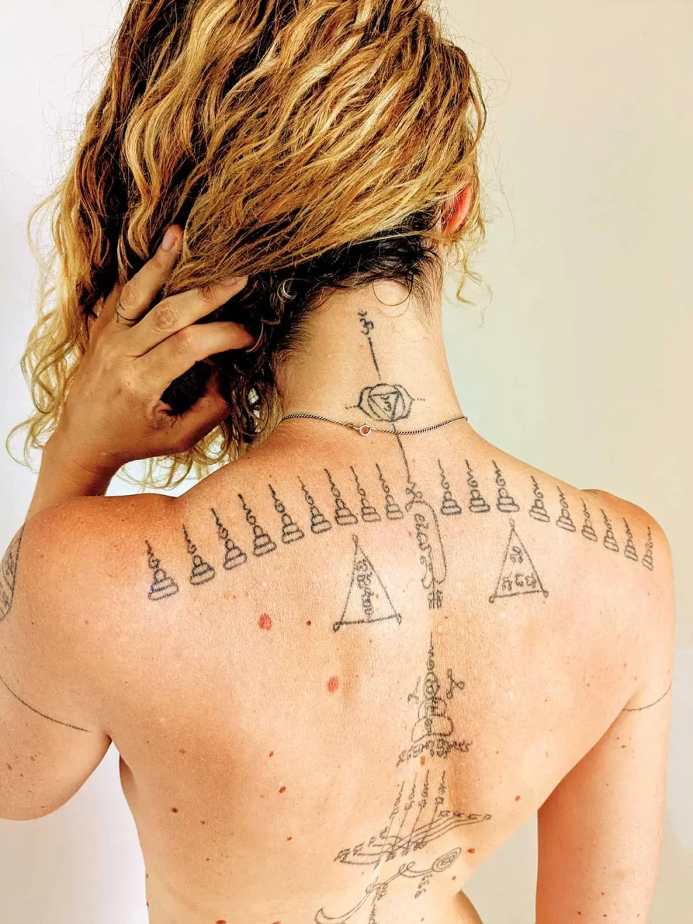 Dos complet chez une femme, motifs multiples et écriture khom, réalisé au handpoke à Bayonne
