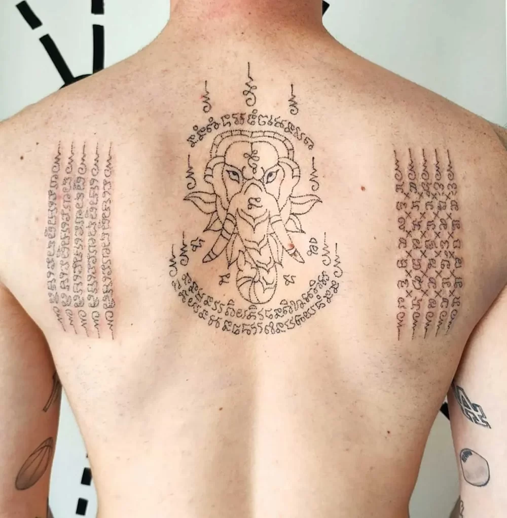 Tatouage thaïlandais Sak Yant motif de l'éléphant, écriture khom sacrée, réalisé au handpoke

