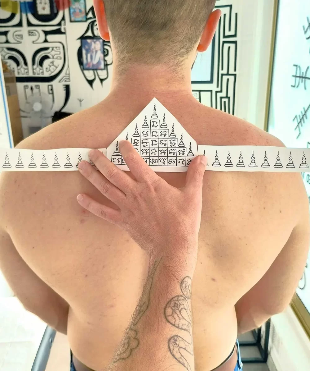 Tatouage thaïlandais Sak Yant Gao Yord, motif des neuf sommets, écriture khom sacrée, réalisé au handpoke
