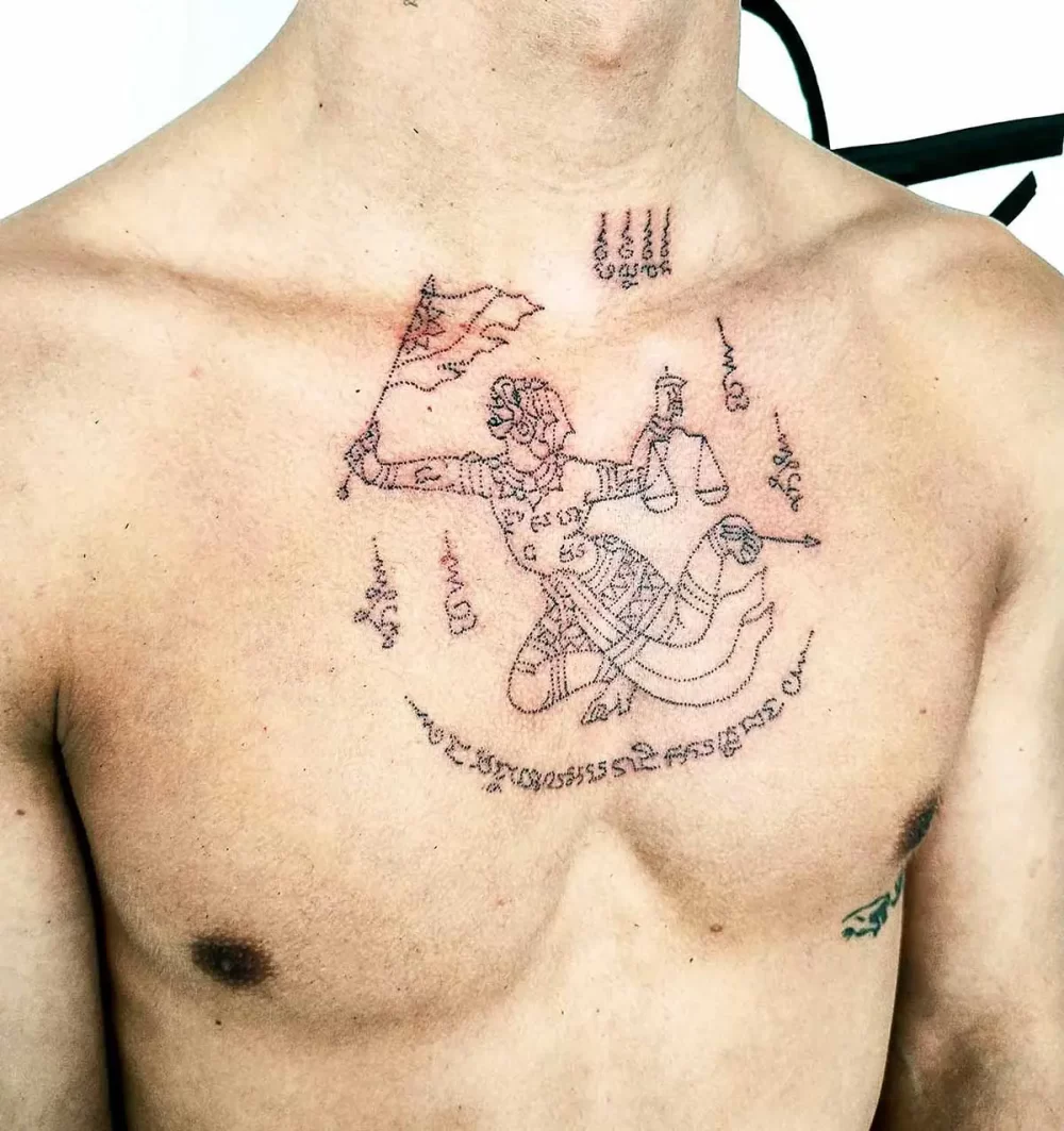 Tatouage thaïlandais Sak Yant Hanuman sur la poitrine, écriture khom sacrée, réalisé au handpoke a Bayonne France