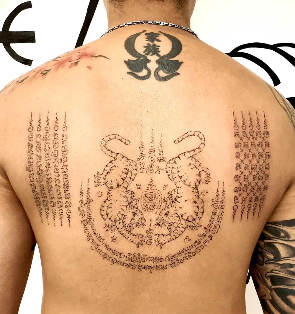Tatouage thaïlandais Sak Yant Tigres Jumeaux dans le dos, écriture khom sacrée, réalisé au handpoke à Bayonne
